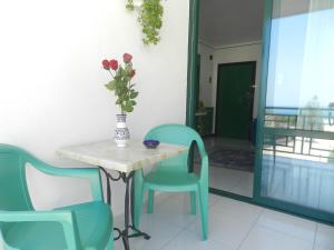 比谢列Il Gabbiano casa al mare的一张桌子、椅子和一个花瓶