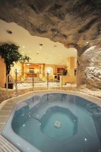 图克斯基希尔休閒酒店的一个带岩石墙的客房内的按摩浴缸