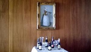 布莱克浦The Albert Hotel Near Winter Gardens的一张桌子,上面放有瓶子和眼镜,墙上挂着一张照片