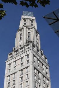 亚眠Le 360 TOUR PERRET 19eme PANORAMA 4 ETOILES的一座高大的建筑,背后是蓝天