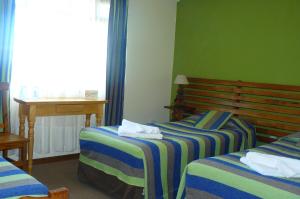 埃尔卡拉法特卡鲁特霍什酒店的酒店客房配有两张床和一张书桌