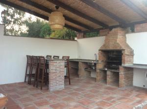 比纽埃拉Casa Lake Viñuela的庭院设有壁炉和桌椅。