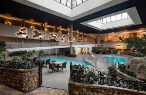 萨斯卡通萨斯卡通会议中心酒店的酒店大堂设有游泳池和桌椅