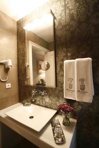 穆斯基斯帕拉西奥姆纳顿尼斯酒店的浴室配有盥洗盆、镜子和毛巾