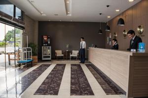 伊达贾伊伊塔雅伊季节101酒店的大厅,有两个人站在柜台