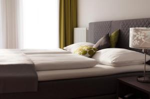 巴特格莱兴贝格费连安库帕克公寓的卧室配有带白色枕头的床和窗户。