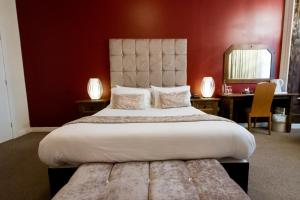 彼得伯勒明珠大酒店的一间卧室设有一张红色墙壁的大床