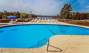 霍利Tanglwood Resort, a VRI resort的一个带椅子和桌子的大型蓝色游泳池
