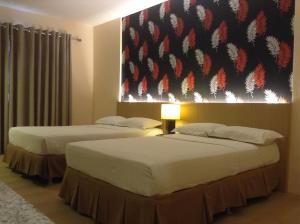 Rosario山海度假村的两张位于酒店客房的床,墙上挂着一幅画