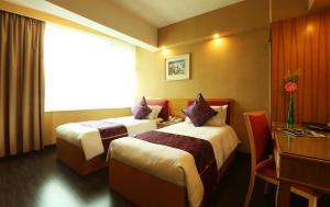香港帝国酒店的酒店客房设有两张床、一张书桌和一个窗户。