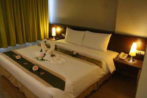 合艾阿罗哈合艾酒店的酒店客房,配有一张带鲜花的大床