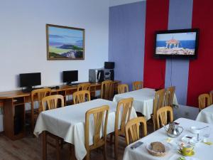 乌兰巴托特索蒙斯服务式公寓的一间设有桌子的用餐室和墙上的电视