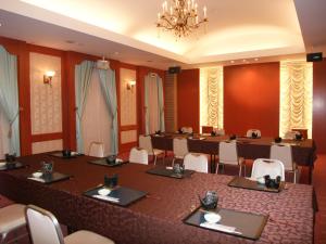 Goshogawara五所川原日道经济型酒店的大型会议室,配有长桌子和椅子