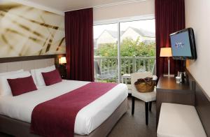 贝桑于潘港奥马哈海滩美居酒店的酒店的客房 - 带一张床、一台电视和一个阳台
