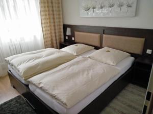 新伊森堡阿尔法酒店的卧室内的两张床,配有白色床单和枕头
