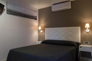 巴塞罗那圣保旅馆的一间卧室配有床和2个床头柜