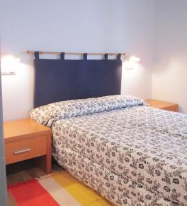 坎加斯德尔纳尔塞亚Apartamentos Legazpi的一间卧室配有床和木制床头柜