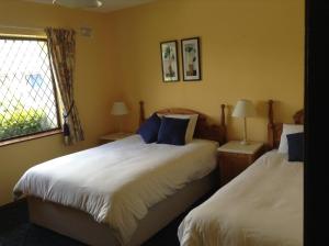 肯梅尔Riverlodge Self Catering的一间卧室设有两张床和窗户。