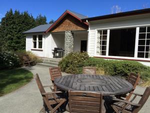 特卡波湖约翰山家园度假屋的房屋前的一张木桌和椅子