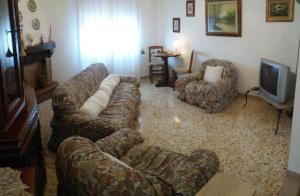 切奇纳Apartment Nonna Cucca的客厅配有沙发、椅子和电视