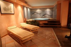 格雷索拉特里尼泰瓦尔维德酒店的一间带长椅和桌子的浴缸的客房