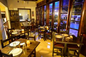 乌巴图巴艾斯特拉格慕卡萨格兰德波萨达酒店的餐厅设有木桌、椅子和窗户。
