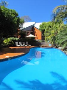 麦夸里港雪莉海滩度假酒店的一个带椅子的大型蓝色游泳池