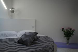 拉齐塞Ca' Ottocento的一间卧室,配有一张带枕头和花瓶的床