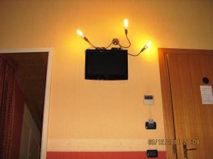 蒙扎莫斯卡酒店 的墙上的电视,上面有两根蜡烛