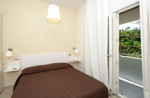 马奥莱甜蜜生活公寓酒店的一间卧室设有一张床和一个大窗户