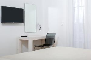 纳克索乔拉纳克索斯公主酒店的一间卧室配有一张桌子、椅子和一台电视