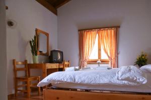 Medels im Rheinwald瓦尔瑟霍夫酒店兼餐厅的一间卧室配有一张床、一张书桌和一个窗户。