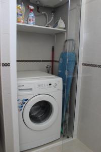 波尔蒂芒Praia da Rocha Tarik的洗衣房配有洗衣机和滑雪板