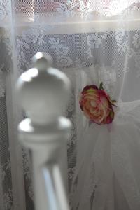 阿西西阿西西索尼住宿加早餐旅馆的白色花瓶的窗帘上有一朵粉红色的玫瑰