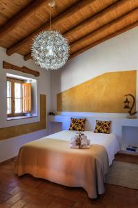圣特奥托纽Monte da Boavista的一间卧室配有一张大床和一个吊灯。
