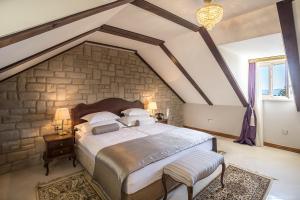 斯普利特辉煌宫住宿加早餐旅馆的一间卧室设有一张带石墙的大床