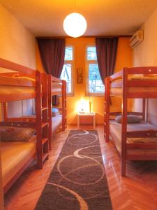 莫斯塔尔Hostel Taso's House的带三张双层床和地毯的房间