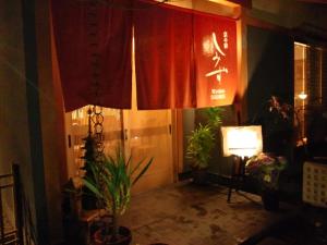 京都清水日式旅馆的一间设有红色窗帘、植物和灯的房间