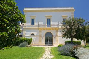 加利波利马赛利亚夫吉酒店的一座大白色房子,在院子里设有大门
