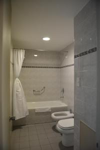 里瓦达维亚海军准将城考莫多罗酒店 的浴室配有卫生间、浴缸和水槽。
