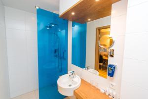凯夫拉维克雷克雅未克机场丽柏酒店的一间带水槽和蓝色玻璃淋浴间的浴室