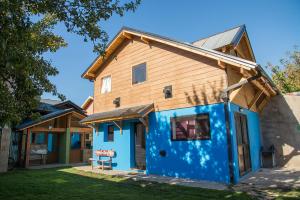 圣马丁德洛斯Sherpa Hostel的蓝色的房屋,设有木屋顶