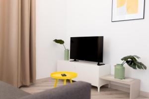 瓦伦西亚华莱士公寓 的一间客厅,在白色的橱柜上配有电视