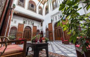 非斯Riad - Dar Al Andalous的大楼内带桌椅的房间