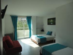 圣玛尔塔Brizzamar Hotel的一间卧室设有两张床、一把椅子和一个窗户。