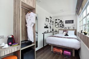 新加坡Hotel Clover The Arts的卧室配有一张床和墙上的一套西装