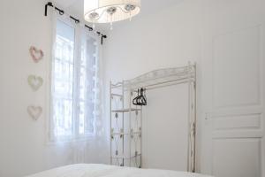 翁弗勒尔带露台公寓的白色的卧室设有床和窗户