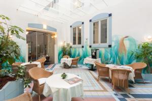 不莱梅不来梅市贝斯特韦斯特酒店的一间带桌椅和壁画的餐厅