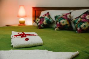 PrylukyAlexandria Hotel的床上的白色毛巾和红色的蝴蝶结