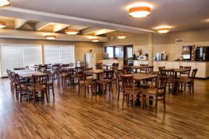 布兰登Lakeview Inns & Suites - Brandon的用餐室配有木桌和椅子